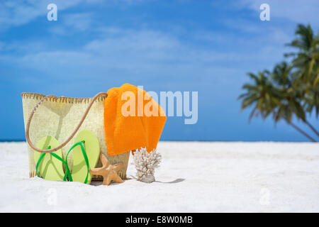 Estate borsa da spiaggia con starfish,asciugamano,cantato i lasses e flip flop sulla spiaggia sabbiosa Foto Stock