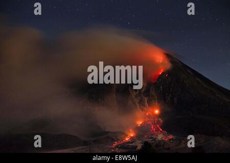 Il nord di Sumatra, Indonesia. Xiii oct, 2014. 14 ottobre: una vista di fuoriesce piroclastici Sinabung dall eruzione del vulcano visto al villaggio Beganding su ottobre 14, 2014 in Karo, nel nord di Sumatra, Indonesia. Gazzetta detto '' oggi, lo stato del vulcano Sinabung alert con classe si verifica un terremoto la lava 49 volte 2 volte un terremoto tettonico lontano, 18 hybrid terremoti. 2 volte il osservato valanghe di nuvole a caldo per quanto riguarda circa 1500-3000 metri di cime a sud, a duemila metri a sud-est, e l'altezza della colonna di acqua calda nube di cenere vulcanica 500-700 m. © Sijori Immagini/ZUMA filo/Alamy Live News Foto Stock