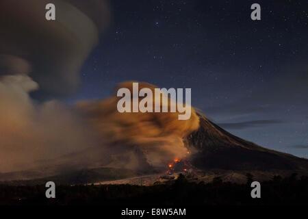 Il nord di Sumatra, Indonesia. Xiii oct, 2014. 14 ottobre: una vista di fuoriesce piroclastici Sinabung dall eruzione del vulcano visto al villaggio Beganding su ottobre 14, 2014 in Karo, nel nord di Sumatra, Indonesia. Gazzetta detto '' oggi, lo stato del vulcano Sinabung alert con classe si verifica un terremoto la lava 49 volte 2 volte un terremoto tettonico lontano, 18 hybrid terremoti. 2 volte il osservato valanghe di nuvole a caldo per quanto riguarda circa 1500-3000 metri di cime a sud, a duemila metri a sud-est, e l'altezza della colonna di acqua calda nube di cenere vulcanica 500-700 m. © Sijori Immagini/ZUMA filo/Alamy Live News Foto Stock