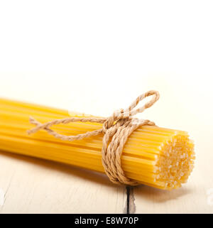 La pasta italiana spaghetti legato con una corda su un tavolo rustico Foto Stock