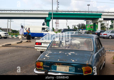 Un vecchio Peugeot 504 e un ponte dipinto con i colori della bandiera nigeriana per le strade della città di Ibadan, Oyo membro Foto Stock