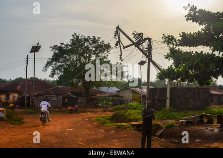 Nigeria rurale che mostra scarsa elettrificazione e scarso accesso all'energia e una lampada pubblica utilizzando un pannello solare Foto Stock