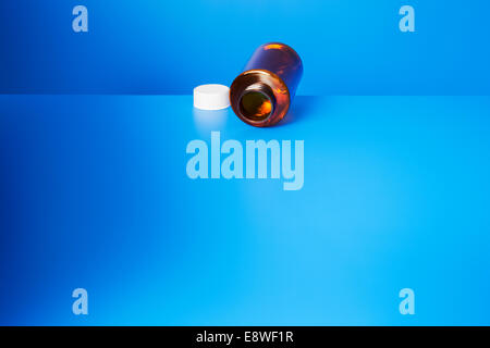 Pillola vuoto bottiglia aperta sul contatore di blu Foto Stock