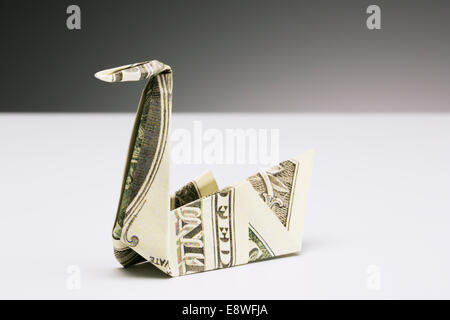 Origami swan fatta di dollari sul contatore Foto Stock