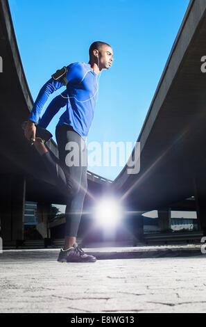 L'uomo stretching prima di esercizio Foto Stock