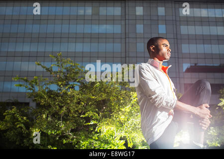 Uomo che allunga la gamba prima di esercizio Foto Stock