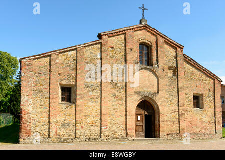 Vista esterna del prospetto principale della antica chiesa romanica nel piccolo villaggio in Piemonte, girato in condizioni di intensa luce a molla Foto Stock