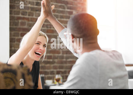 La gente di affari ad alta fiving alla riunione in cafe Foto Stock