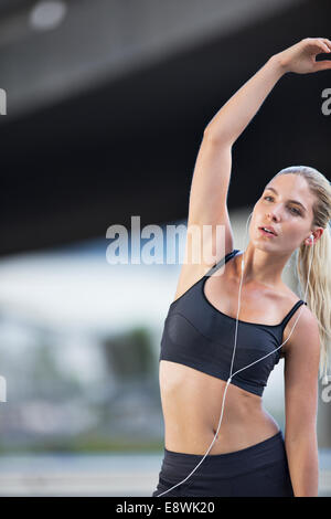 Donna stretching prima di esercitare sulla strada di città Foto Stock