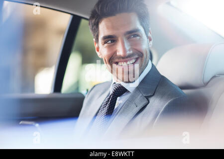Imprenditore sorridente seduto in auto Foto Stock