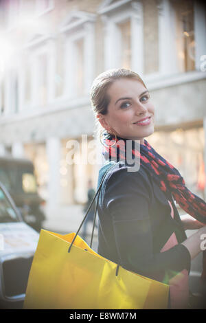 Donna con shopping bag attraversando via della città Foto Stock