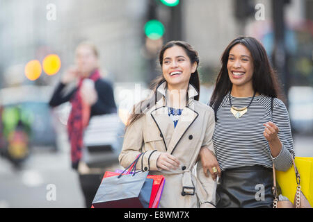 Donne in cammino insieme lungo una strada di città Foto Stock