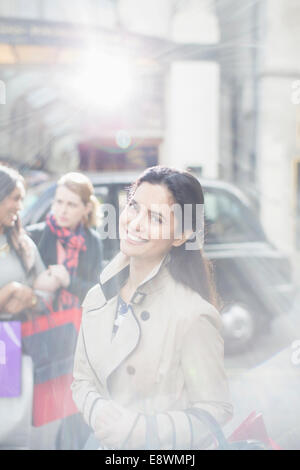 Donna sorridente su una strada di città Foto Stock