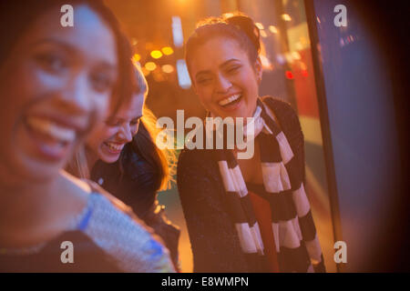 Amici a giocare su una strada di città di notte Foto Stock