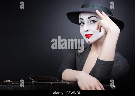 Ritratto di donna mime con una valigia su uno sfondo nero Foto Stock