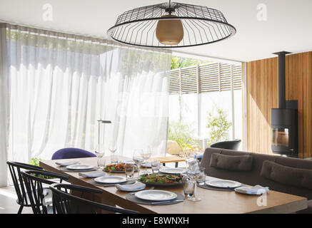 Lampadario sopra un tavolo da pranzo in una moderna sala da pranzo Foto Stock