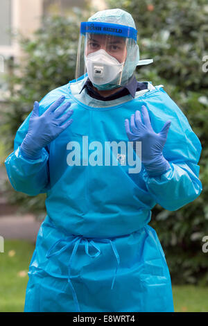 Daniel Peter medico presso la "Arbeiter-Samariter-Bund-Schnelleinsatzteam Veloce' (Primo aiuto samaritano squadre), presenta gli indumenti di protezione durante un virus di Ebola informazioni evento di Colonia, Germania, 15 ottobre 2014. La tuta protettiva della categoria III 3.4.5.6. è particella- e resistente ai liquidi ed è utilizzata nella lotta contro il virus di Ebola in Africa. L'alleanza di organizzazioni umanitarie tedesche "Aktion Deutschland hilft' e l'ASB informa i dipendenti delle varie organizzazioni di aiuto sulla utilizzazione di Ebola abbigliamento protettivo e il trattamento in Germania. Foto: Matthias esitano di fronte/dpa Foto Stock