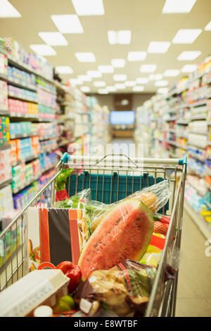 Carrello pieno di shopping nel negozio di alimentari corsia Foto Stock