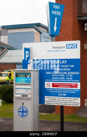 Pagare e misuratore di visualizzazione per emettere i biglietti e tariffe parcheggio / velocità di carica segno, in un ospedale di NHS Parcheggio Auto. Regno Unito Foto Stock