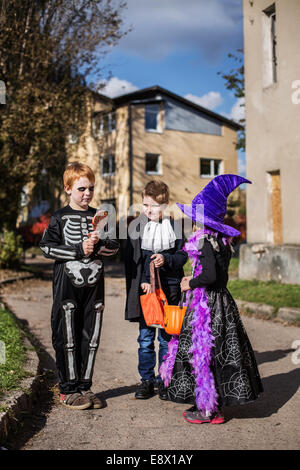 Tre adorabili Trick or treaters mendicando per Halloween Candy Foto Stock