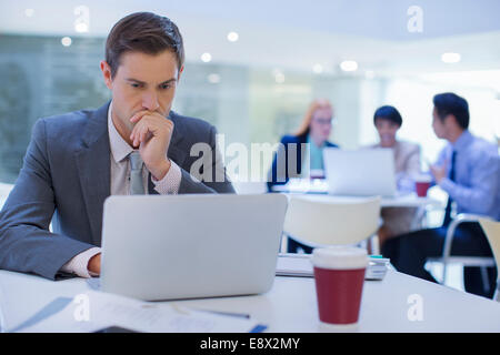 Imprenditore lavora su laptop a tavola Foto Stock