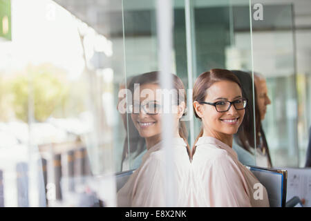 Imprenditrice in piedi in edificio per uffici Foto Stock