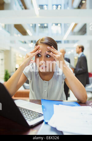 Sottolineato imprenditrice lavorando in ufficio edificio Foto Stock