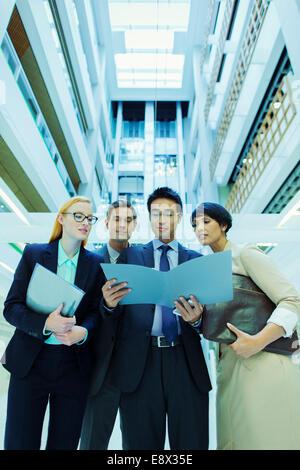 La gente di affari guardando il file in edificio per uffici Foto Stock