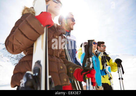 Amici in piedi con gli sci sulla cima della montagna Foto Stock