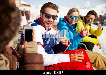 Donna di scattare le foto di amici nella neve Foto Stock