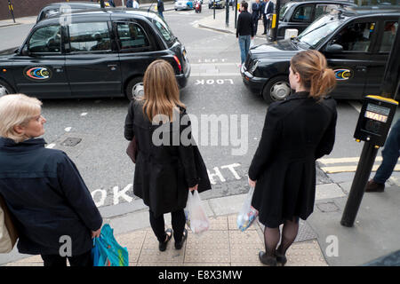 Londra REGNO UNITO. Il 15 ottobre 2014. Ufficio lavoratori attendere su Long Lane al semaforo nei pressi del Barbican tube station per taxi e luci per cambiare. KATHY DEWITT/Alamy Live News Foto Stock