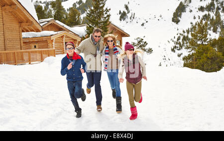 Famiglia in esecuzione nella neve insieme Foto Stock