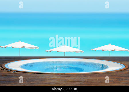 Svuotare jacuzzi di fronte ad una spiaggia di sabbia con un blu oceano Foto Stock