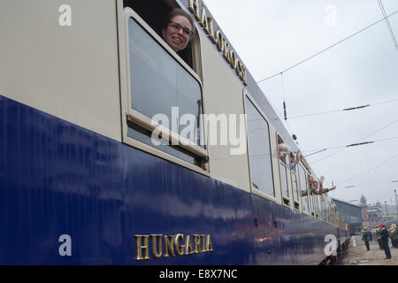 Budapest, Ungheria. 16 ottobre, 2014. Onda di passeggeri come Golden Eagle Danubio Express treno lusso lascia la stazione ferroviaria occidentale di Budapest, Ungheria, dal 15 ottobre 2014. Golden Eagle Danubio Express tirato fuori Budapest la Stazione Ferroviaria Ovest su Ott. 15, dando dei calci a fuori di un 13-giorno di 7.000 chilometri di percorso a Teheran, Iran. La tariffa è di 10.000 a 15.000 dollari USA. Il treno si compone di 13 rinnovato vecchie automobili di lusso, i quali sono tutti i pezzi del museo. Credito: Xinhua/Alamy Live News Foto Stock