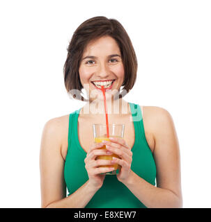 Ritratto di una giovane donna di bere un succo di arancio con una cannuccia, isolato su bianco Foto Stock