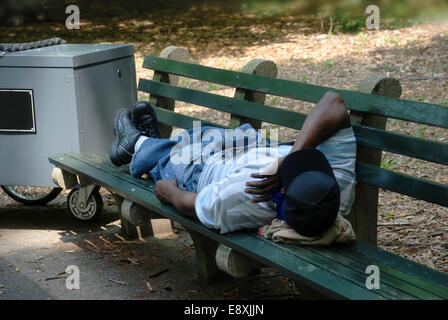 Lavoratore di dormire su una panchina nel parco Foto Stock