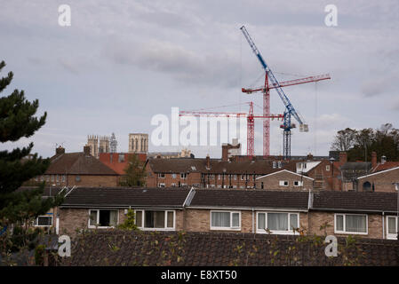 Vista sui tetti di York, North Yorkshire, Inghilterra, Regno Unito - 3 antiche Minster torri e 3 moderne gru che sovrasta le case di C 20 alloggiamento station wagon. Foto Stock