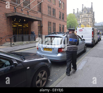 Manchester, Regno Unito. 16 ottobre, 2014. Un parcheggio operaio controlli sulle vetture di Lloyd Street, dove oltre 1700 i biglietti per il parcheggio sono stati rilasciati per il parcheggio illegale dal 2008 al 2013, il quarto più alto per qualsiasi strada in Greater Manchester. Credito: Giovanni friggitrice/Alamy Live News Foto Stock