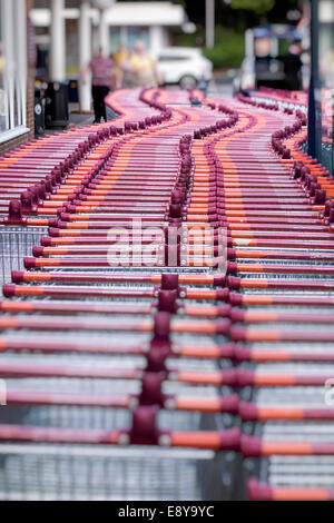 Una fila di carrelli parcheggiati al di fuori di un Sainsbury's supermercato, Surrey, Regno Unito Foto Stock