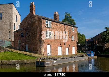 Ex detentore di bloccaggio's cottage sulla Ashton Canal, Ancoats, Manchester, Inghilterra, Regno Unito. Islington Wharf Mews appartamento blocco dietro. Foto Stock