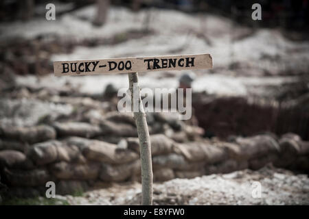 WW1 no mans land ricreazione, il cartello in legno per 'Bucky-Doo trincea' nella parte anteriore di sacchi di sabbia e le trincee. Foto Stock