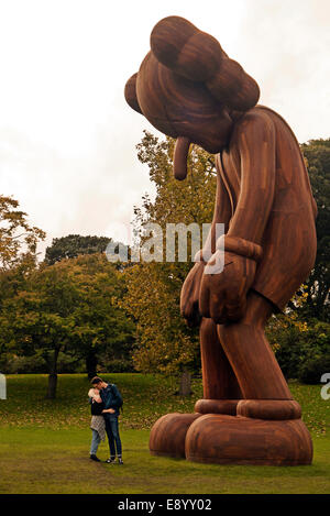 Londra, Regno Unito. Xvi oct, 2014. Gigantesca scultura in legno piccoli giacciono da KAWS in fregio art fair Sculpture Park in Regents Park Londra UK Credit: Martyn Goddard/Alamy Live News Foto Stock