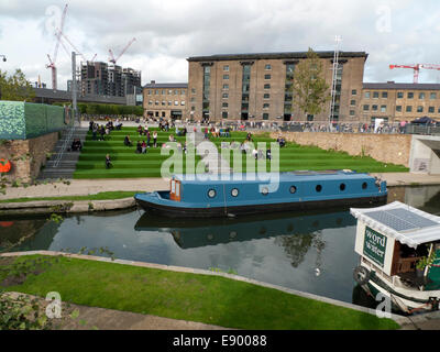 Londra REGNO UNITO. Il 16 ottobre 2014. In un caldo pomeriggio autunnale alle persone di mangiare a pranzo da cucina di strada furgoni sul astroturf passi fuori UAL Università delle Arti di Kings Cross da Regents Canal. KATHY DEWITT/Alamy Live News Foto Stock