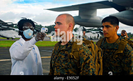 Marines americani dalla speciale scopo Marine Air Ground Task Force di risposta alle crisi, ottenere la loro temperatura controllato come essi uscire una KC-130 i trasporti aerei in arrivo il 9 ottobre 2014 a Monrovia, Liberia. I marines vi assisterà nella costruzione di Ebola e unità di trattamento in più duro per raggiungere le zone della Liberia in uno sforzo per contenere il virus Ebola focolaio nella zona ovest di nazioni africane. Foto Stock