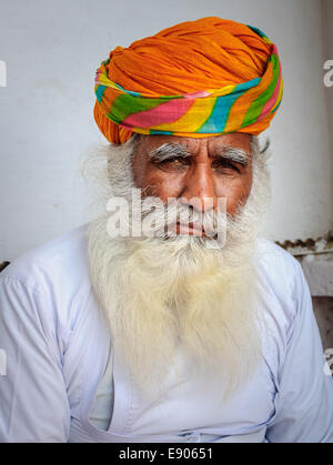 Ritratto di un vecchio di Rajasthani uomo con bianca barba fluente e tradizionale turbante colorato sulla sua testa in abito bianco. Foto Stock