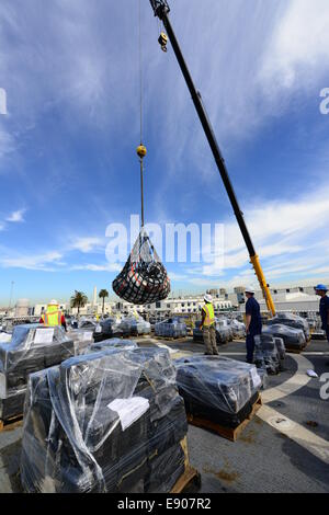 Stati Uniti Costa guardie civili e gli operatori della gru offload 28.000 libbre di cocaina dall'alto endurance taglierina Boutwell USCGC WHEC (719) Presso la Base Navale di San Diego, 6 ott. 2014. La cocaina è stata sequestrata nel corso 18 interdictions separato al largo della costa di Sou Foto Stock