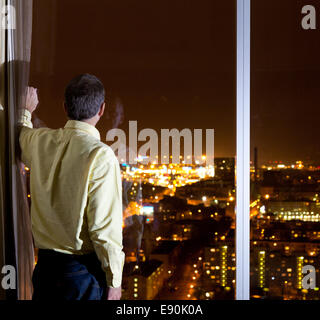 Uomo che guarda sulla città Foto Stock