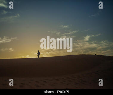 Silhouette di uomo sulle dune di sabbia nel deserto del Sahara Foto Stock