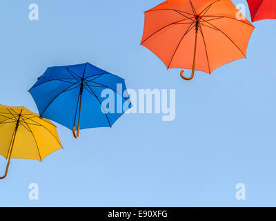 Ombrelloni colorati floating contro un cielo blu Foto Stock