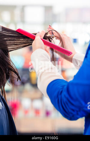 Coiffeur donna il taglio di capelli di donne in parrucchiere Foto Stock